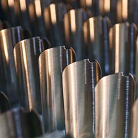 close-up view of several metallic, curved blades or fins, arranged in parallel rows