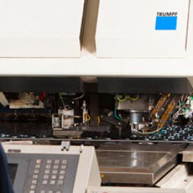 person standing in front of a large industrial machine labeled 